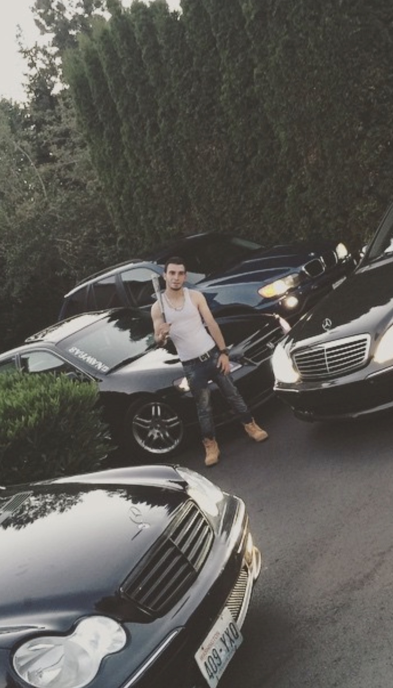 Nowrs standing between Mercedes cars